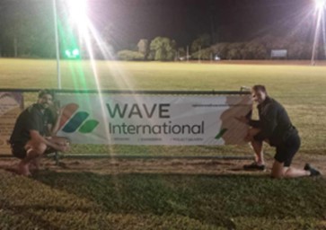 Wave International Gladstone in front of the Wave International banner during Saturday night lights at the BITS Saints AFL team ground.